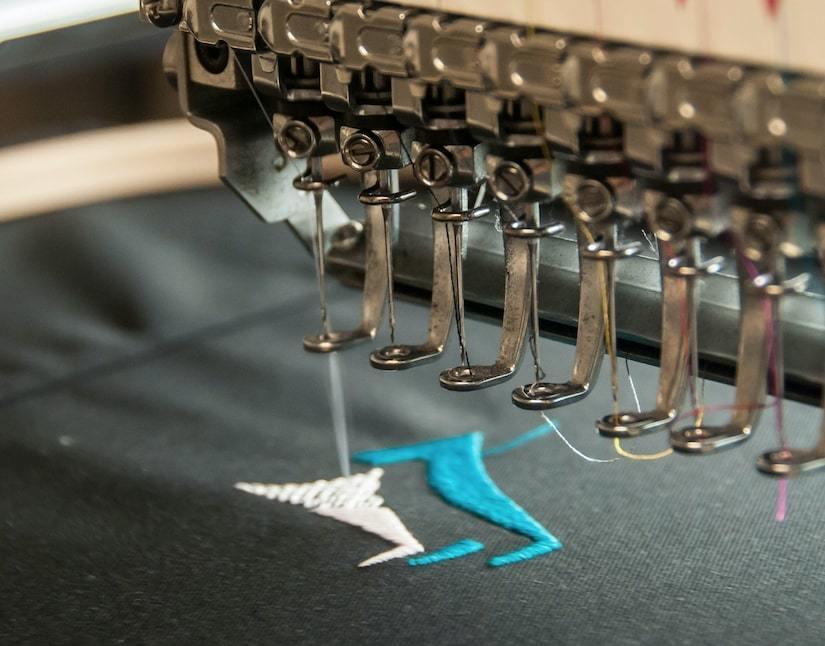 Commercial embroidery machine producing customised branded apparel and uniforms for business clients.