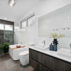 Beautifully tiled En suite with dual vanitie, plenty of storage, bath and large walk in shower recess