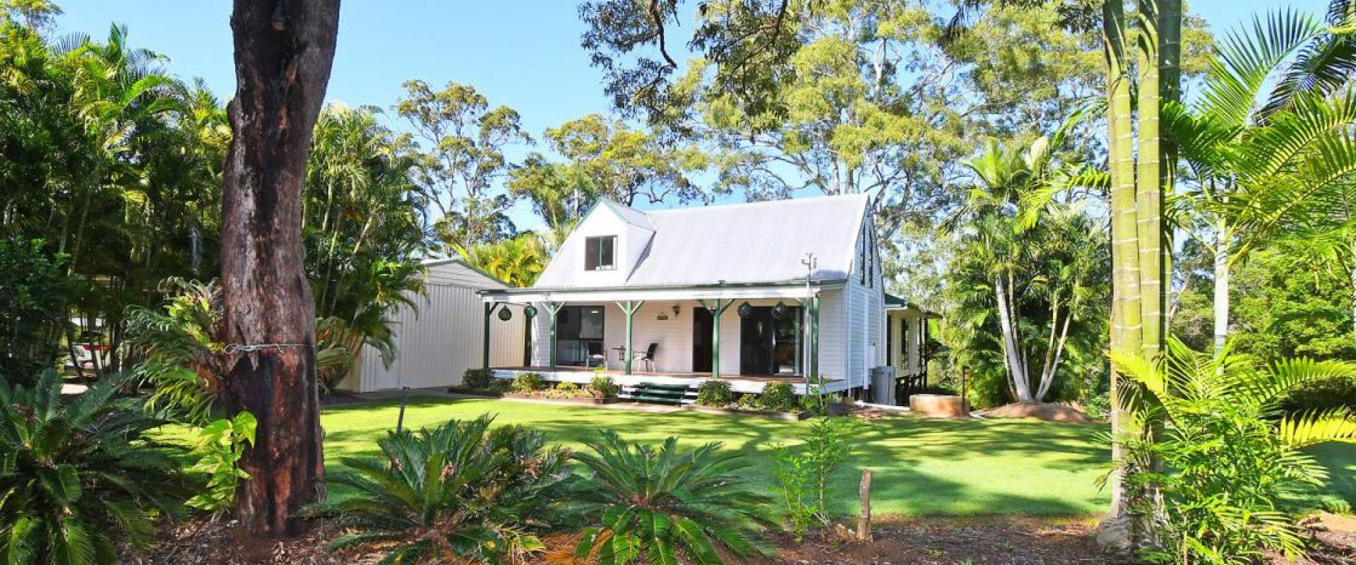ELEVATED CHARACTER HOME SET IN A SYLVAN SETTING, OVERLOOKING AND WITH DIRECT ACCESS TO THE BURRUM RIVER - 2.5 ACRES OF WELL MANICURED PRIVATE GROUNDS.